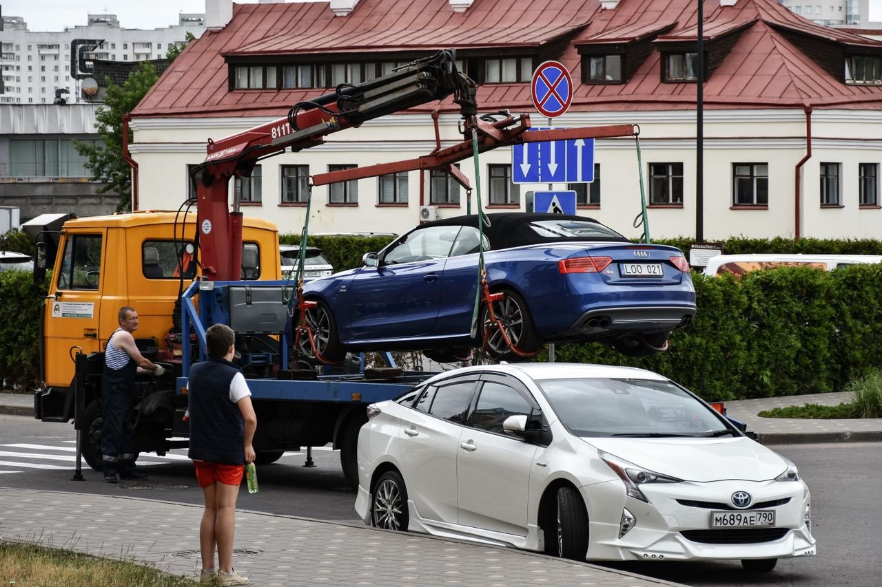 Crafting Captivating Headlines: Your awesome post title goes here Towing a blue Audi convertible in a bustling city street.